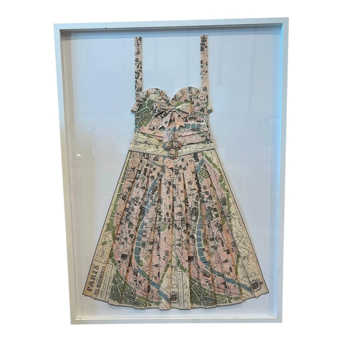 Framed Dress Handmade From a Vintage Map of Paris: Dress hand-made from a Vintage Map of Paris within a Shadow Box of Plexiglass Custom Framed in a Simple White-Painted Wood. Rosettes, bow, sweetheart neckline and pleated details. Inspired by