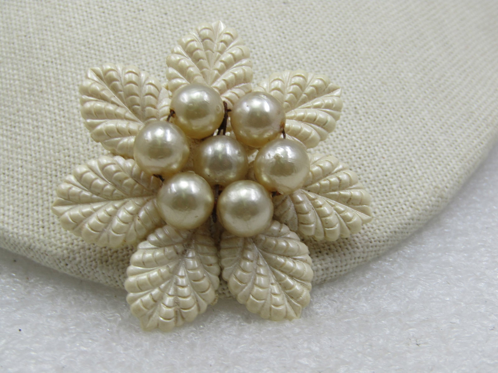 Vintage Celluloid Floral Faux Pearl Brooch, 2": Vintage Celluloid Floral Faux Pearl Brooch, 2". White textured petals with a center round cluster of 9mm faux pearls. Plastic pin back with metal pin with c-clasp. 1930's. Reserve: $30.00 Shipping: Do