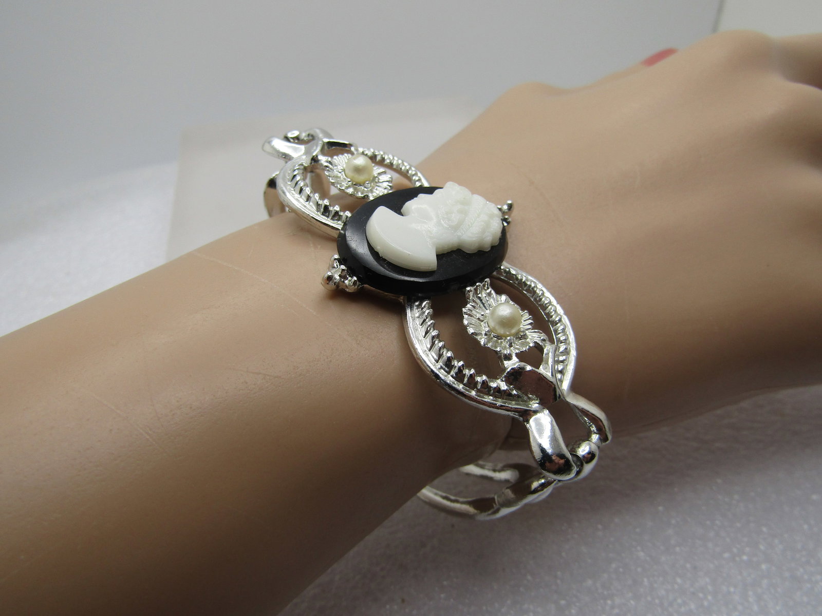 Vintage Black & White Cameo Bracelet, Faux Pearls, 1960's, 6.75": Vintage Black & White Cameo Bracelet, Faux Pearls, 1960's, 6.75". Silver tone with a black and white molded plastic cameo at top center and an open circle on each side with a textured center with a fa
