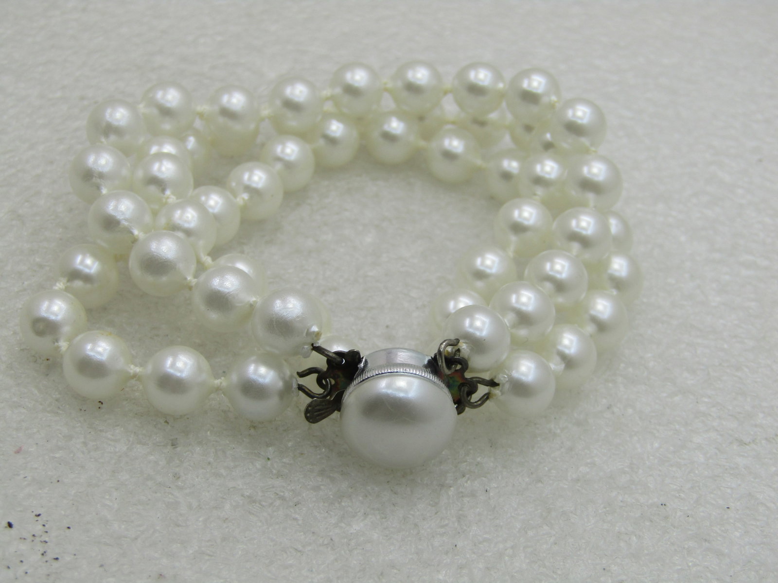 Vintage Triple Strand Faux Pearl Bracelet, Hong Kong, 7.5": Vintage Triple Strand Faux Pearl Bracelet, Hong Kong, 7.5" with a pearl box clasp. Three strands of appx. 7.5mm white pearls that have a knot between each costume pearl. This is in very good