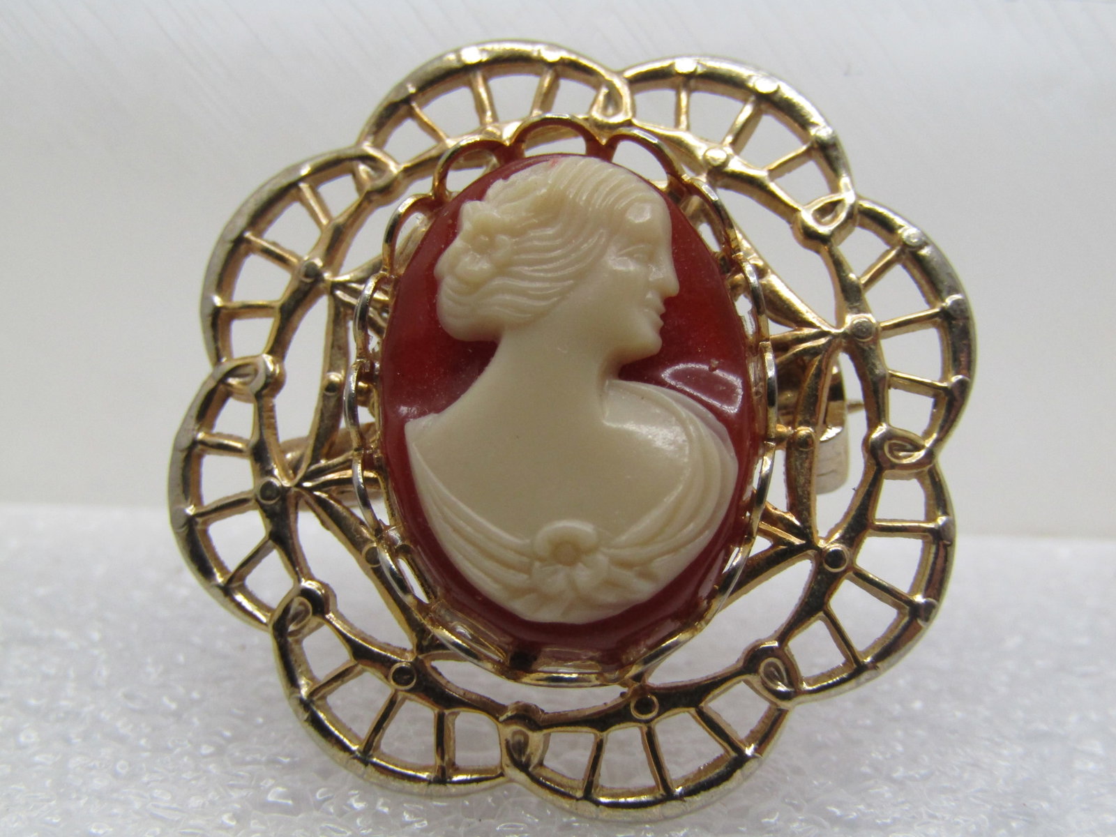 Vintage Cameo Brooch, Filigree Frame, 1960's-1970's: Vintage Cameo Brooch, Filigree Frame, 1960's-1970's. Costume cameo brooch with filigree scalloped frame with a bezel-set costume cameo set on top. The brooch is round and appx. 1-1/8" across. It has
