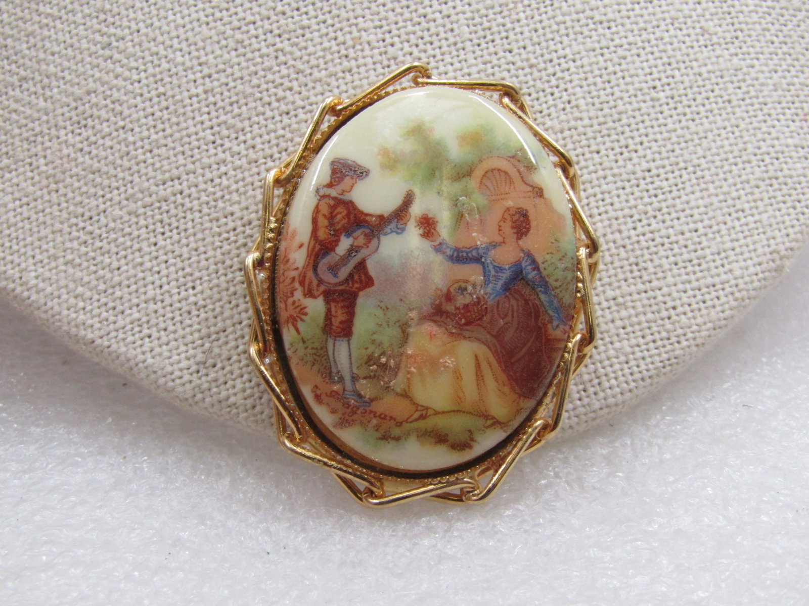 Vintage French Courting Scene Cameo Brooch/Pendant 2": Vintage French Courting Scene Cameo Brooch/Pendant 2" by 1.5", 1960's, gold tone linked frame. The woman is listening to music by her courter while sitting in a meadow scene Very good condition. (W113