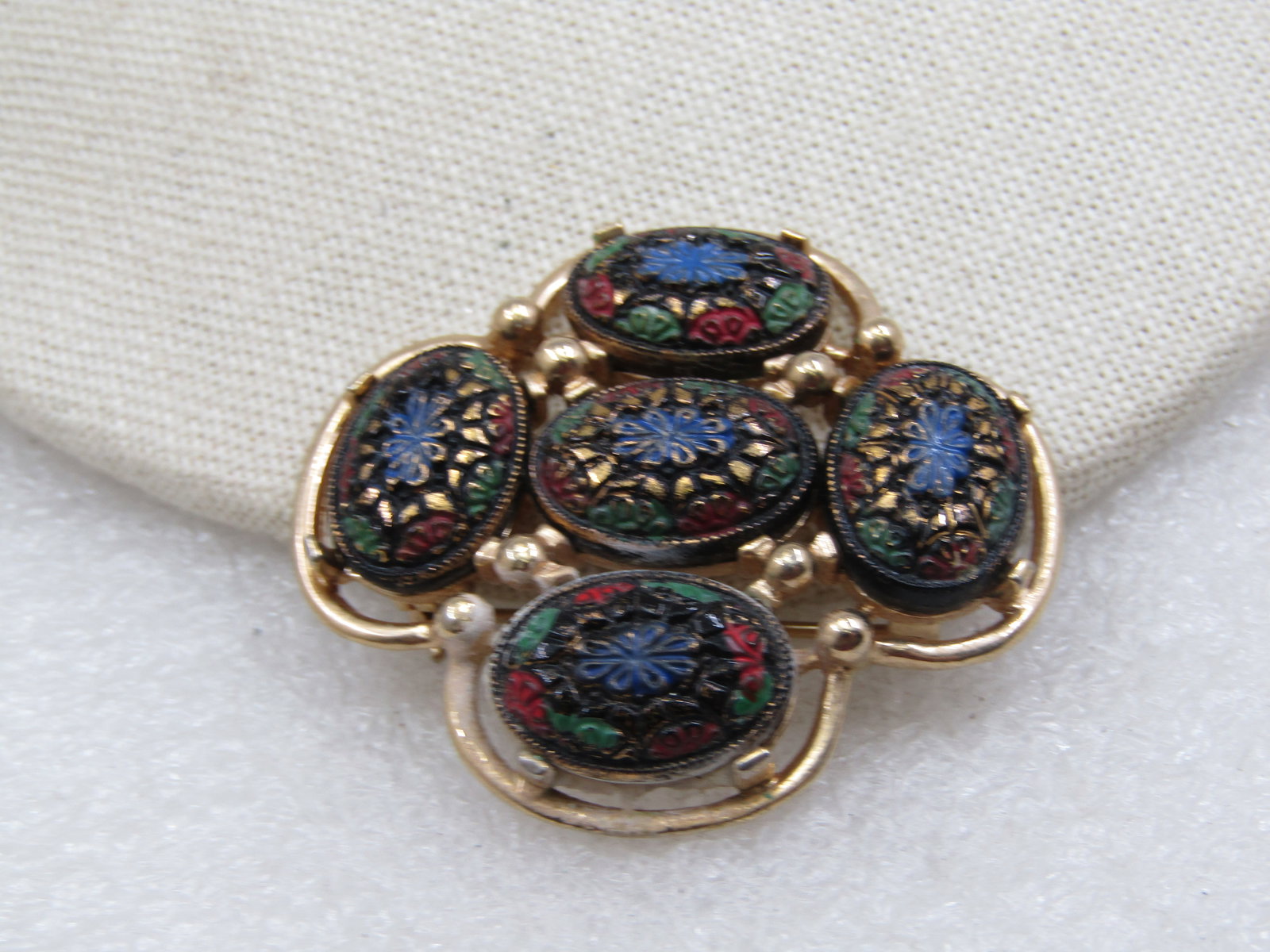 Vintage Floral Pressed Cameo Style Sarah Coventry Brooch, 1960's-1970's: Vintage Floral Pressed Cameo Style Sarah Coventry Brooch, 1960's-1970's, gold tone. 2" by 1.75". Five oval pressed lucite style floral cameos, black background with enameled flowers and gold enameled 