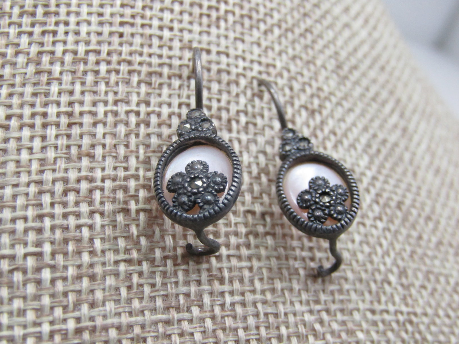 Vintage Sterling Mother-of-Pearl Marcasite Earrings, Pierced: Vintage Sterling Mother-of-Pearl Marcasite Earrings, Pierced. 1" from curved in post, locking hook posts. Framed mother-of-pearl with a marcasite blossom set on the bottom of the frame and above the