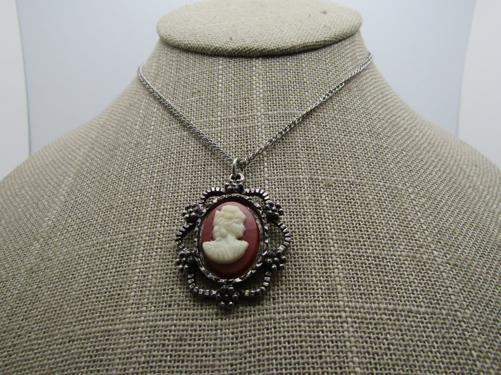Vintage Cameo Necklace, 17", Silver tone, 1960's: intage Cameo Necklace, 17", Silver tone, 1960's. Butterscotch and white molded plastic cameo in an open scrolled frame with a 1.5mm wide curb link chain with spring clasp. It is not signed by the make