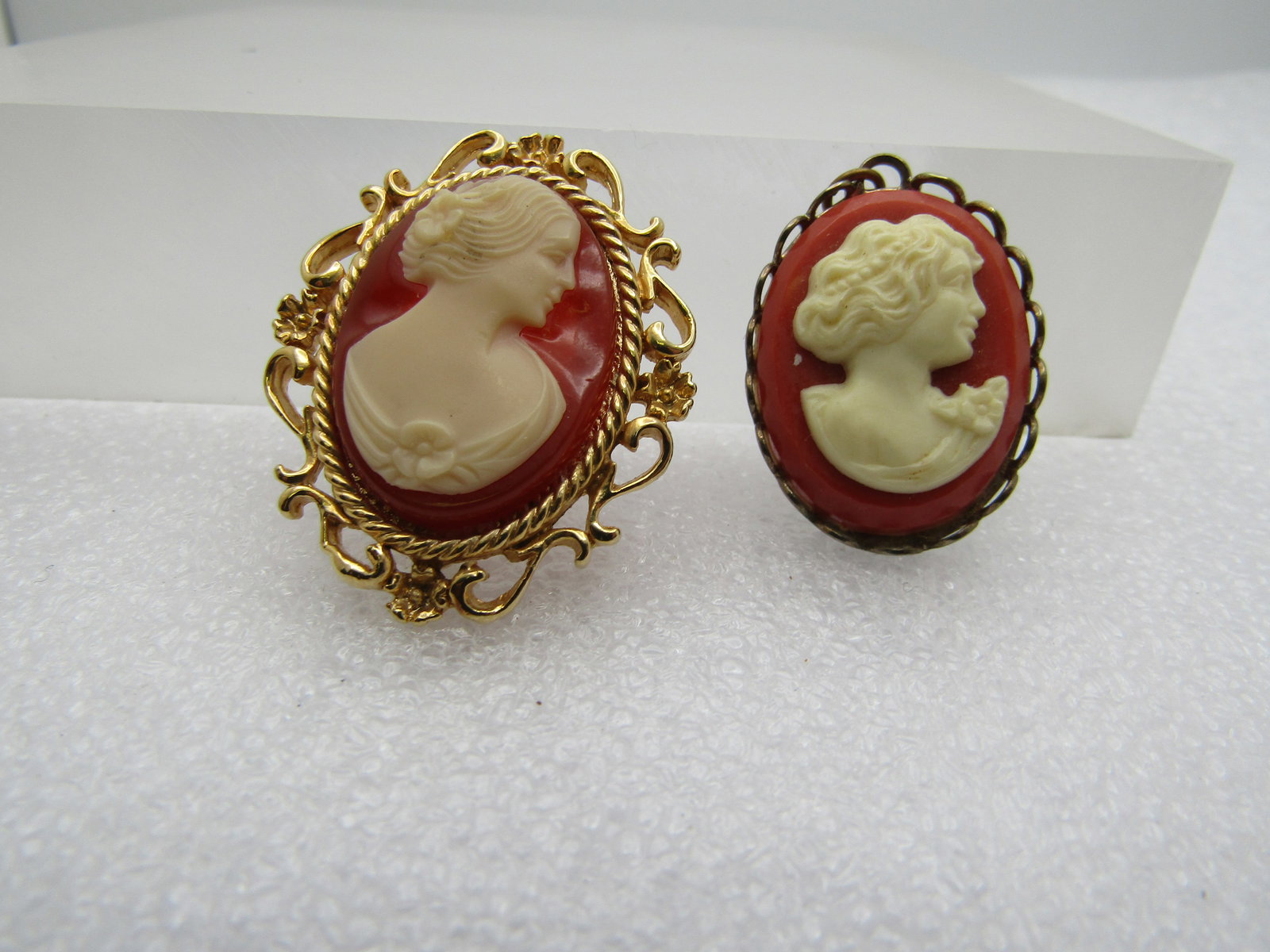 Vintage Cameo Brooch & Pendant, 1960's: Vintage Cameo Brooch & Pendant, 1960's. The brooch hs a scrolled frame and is appx. 1-1/3" tall and 1" wide. Gold tone and not signed by the maker. Very good condition. Gold tone cameo pendant, molded