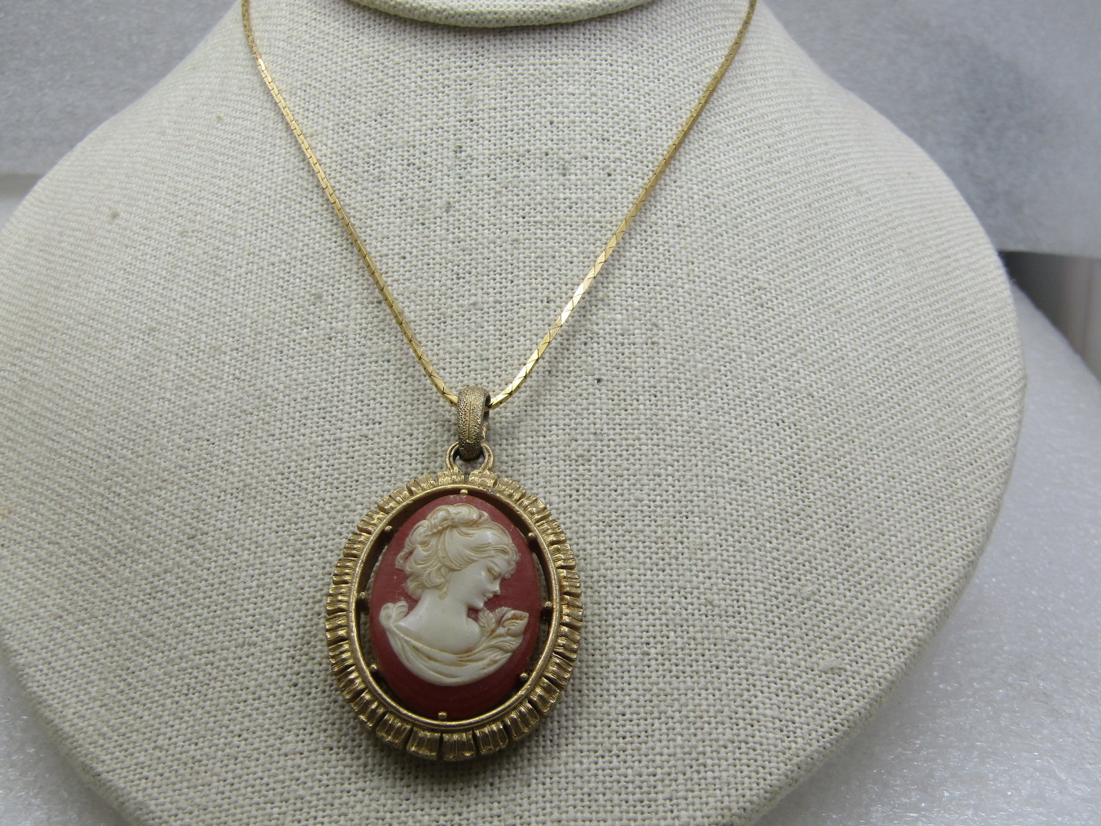 Vintage Cameo Necklace, 16", 1960's, Two-Sided Pendant: Vintage Cameo Necklace, 16", 1960's, Two-Sided Pendant. Thsi is a molded cameo in a carnelian colored background with off-white cameo in an open area between the cameo and the ridged frame. Swing bale