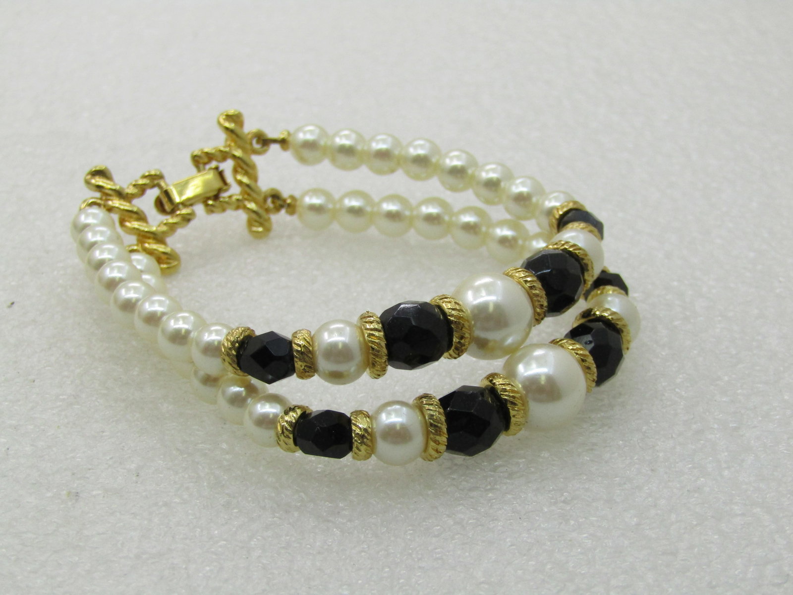Vintage Double Strand Faux Pearl Bracelet, 7": Vintage Double Strand Faux Pearl Bracelet, 7", Graduated from 5.5mm to 9.5mm in white faux pearls with black glass faceted beads spacedin the center at 5mm to 9.5mm with gold textured spaced disc bead