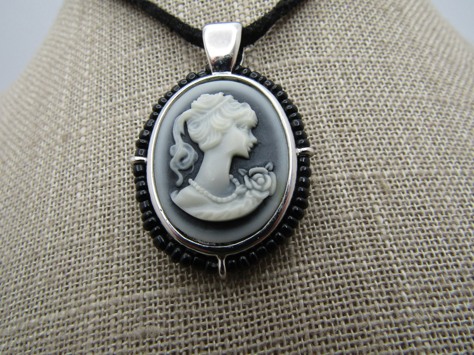Vintage Black Cameo Necklace, 21" Suede and Beaded, Lia Sophia. 2000's: Vintage Black Cameo Necklace, 21" Suede and Beaded, Lia Sophia. 2000's. The cameo is silver tone with a black faded base and white to gray edging and white cameo. It is framed with black glass seed