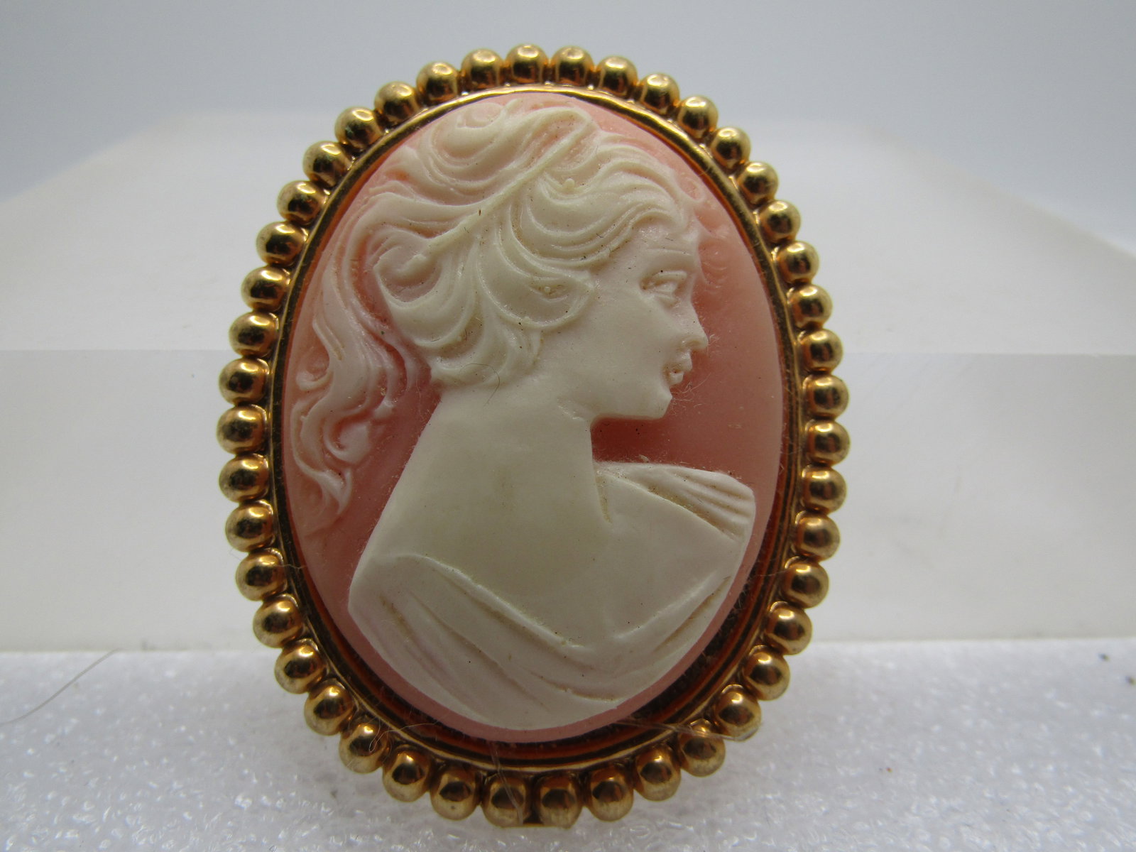 Vintage Cameo Brooch, 1960's, Gold Tone: Vintage Cameo Brooch, 1960's, Gold Tone. It has a beaded-like frame with a molded cameo with a craved look . It is 2" tall and 1.5" wide. It is not signed or marked. Very good conditon. (W111123.5 SS1