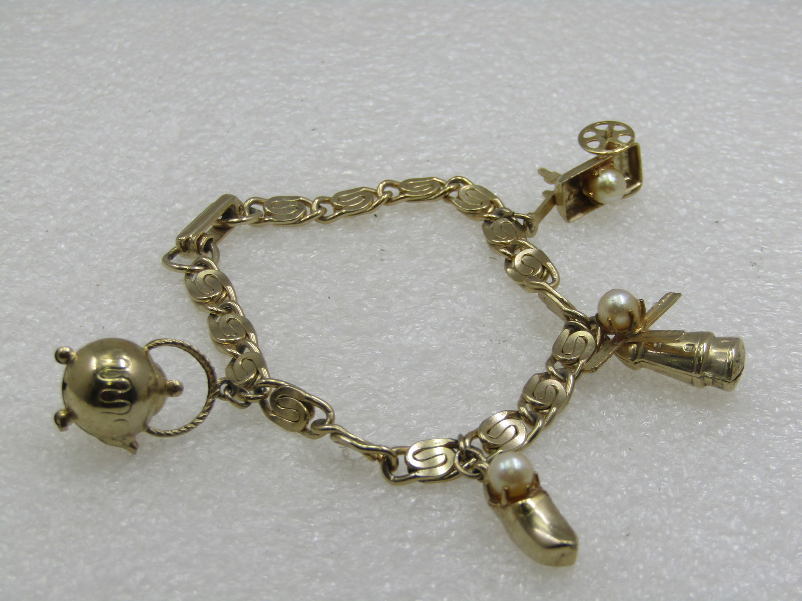 Vintage Gold Tone Charm Bracelet, 1960's, Faux Pearl, 7": Vintage Gold Tone Charm Bracelet, Faux Pearls, 1960's, 7". Dutch charms - teapot, hay wagon with spinning wheels, Windmill with spinning blades, Dutch shoe. All charms have a signe faux pearl that is 