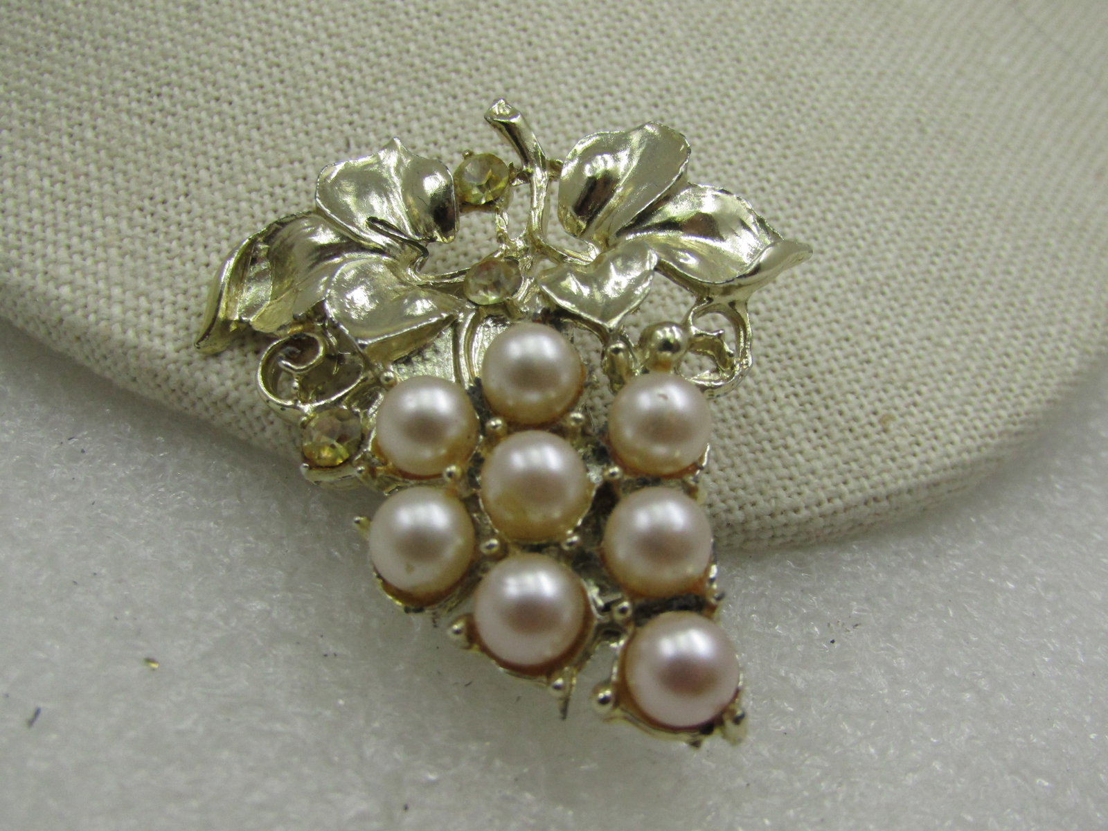 Vintage Faux Pearl Yellow Rhinestone Grape Brooch, 1950's-1960's: Vintage Faux Pearl Yellow Rhinestone Grape Brooch, 1950's-1960's. A cluster of grapes with gold tone stem and leaves and 8 appx. 5.5mm faux pearls with a few pale yellow rhinestones throughout. 2" tal