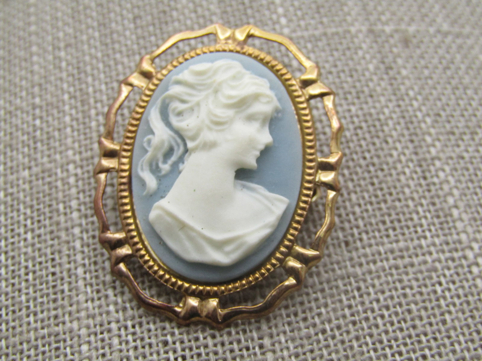 Vintage Faux Wedgewood Cameo Brooch, 1950's-1960's. Gold tone with open space around the frame and: Vintage Faux Wedgewood Cameo Brooch, 1950's-1960's Reserve: $20.00 Shipping: Domestic: Flat-rate of $7.00 to anywhere within the contiguous U.S. International: Foreign shipping rates are determined by