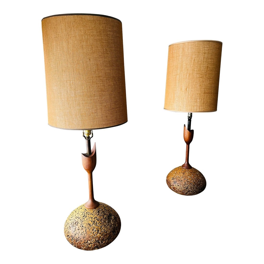 1970s Cork and Walnut Tulip Table Lamps Attributed to Adiran Pearsall: A rare matching pair of Mid-Century table lamps with textured cork bases, and sculpted tulip walnut stems and rattan drum shades. Attributed to designers like Adrian Pearsall and Paul Frankl, the desi