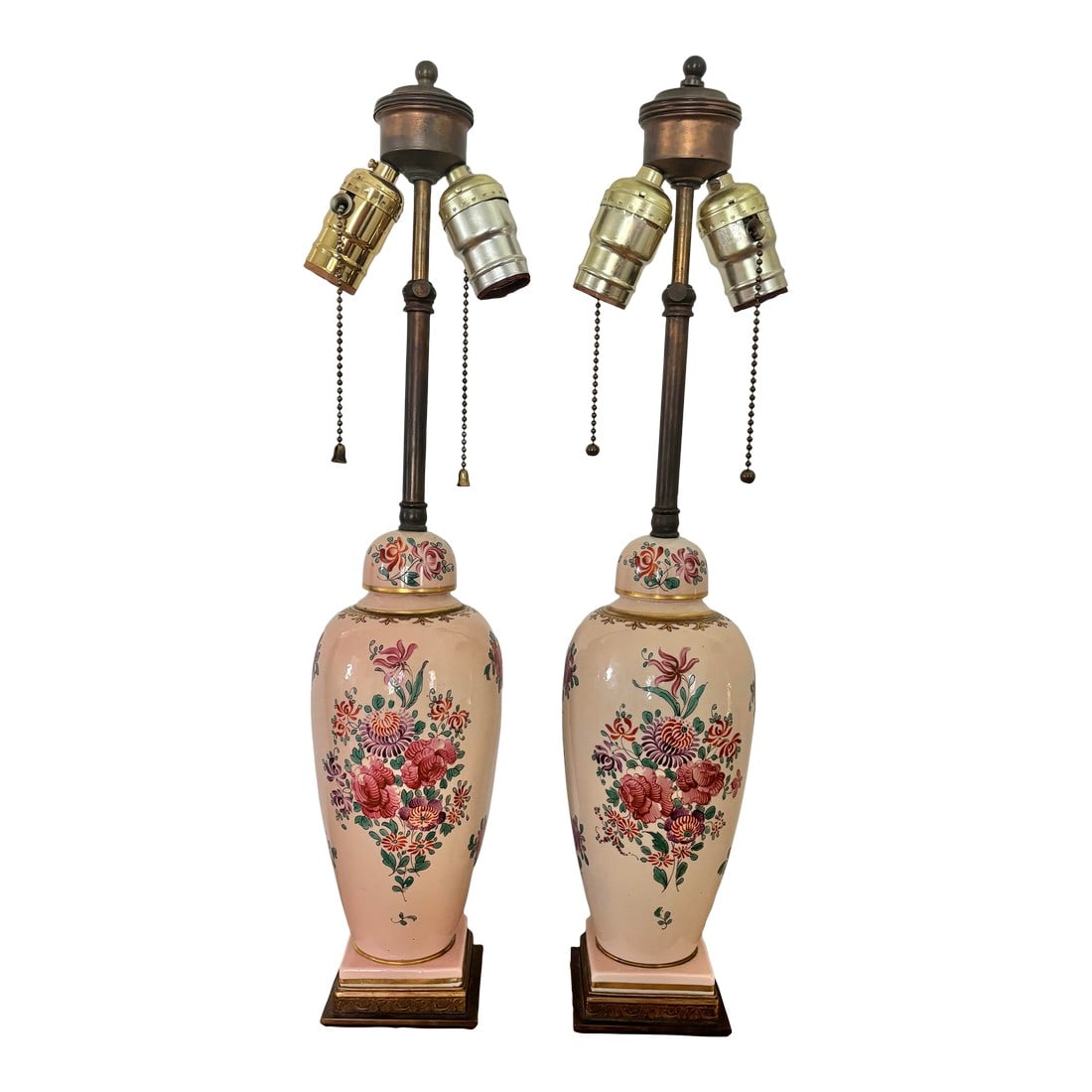 Antique Hand Painted Floral Motif Lamps - A Pair: Dorothy Draper style rare pair of 1940s pink porcelain lamps hand-painted with colorful florals and gold accents on the original tiered and embossed brass bases. Each has two light sockets with pull