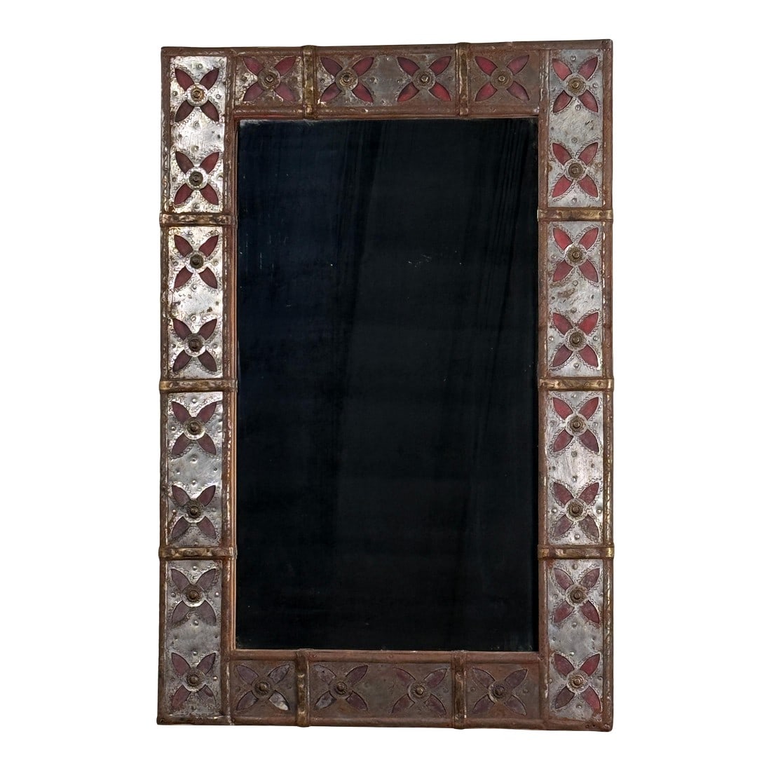 Vintage Spanish Colonial Style Patchwork Cut Metal Wall Mirror With Moorish Motif Frame: This wall mirror features a rectangular glass mirror set within a patchwork cut metal frame with raised Moorish style red cross motifs and a mixed metal surface. It measures 23.75 inches wide, 35.5