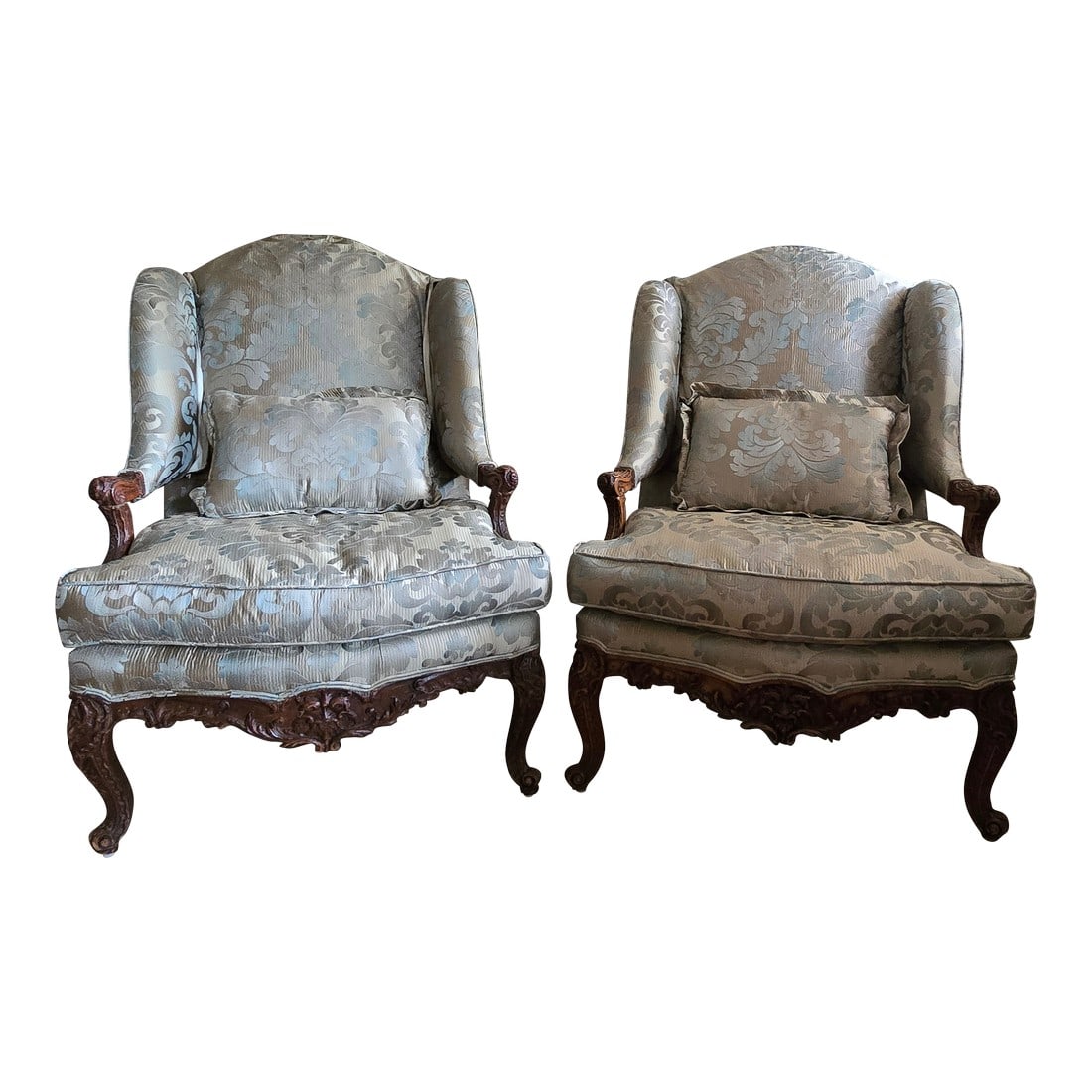 Pair of Early 18th Century Bergere Armchairs, Hand-Carved Walnut, Made in France: An exquisite pair of French Regency (1715-1723) walnut bergere armchairs, hand-carved and richly detailed. Crafted in France in early 18th century, featuring an intricate floral motif on a sculptural
