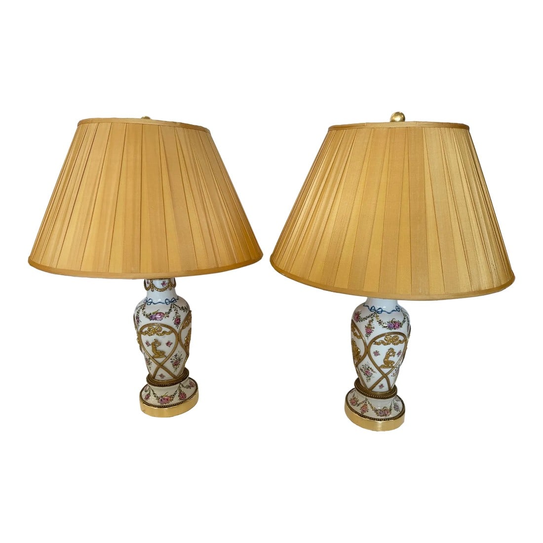 Vintage Porcelain Painted Table Lamps With Brass Overlays -A Pair: Very pretty pair of white porcelain table lamps having painted pink flowers and green garlands embellished with brass overlay of bows and figures. Condition: Alterations: Original Condition Unaltered 
