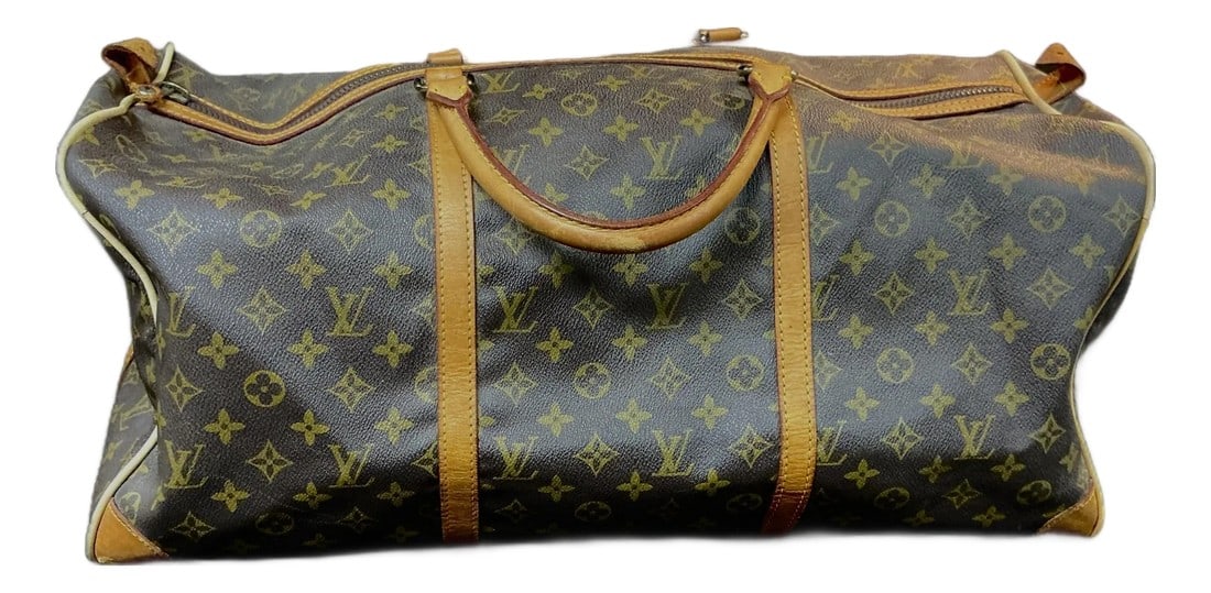 Vintage Louis Vuitton Monogram Keepall 20 Inch Duffle Bag: Early 20th Century Louis Vuitton Duffle Bag features iconic brown monogrammed bag with solid leather rolled handles and trim with brass hardware. Bag has a top zipper closure, an interior small