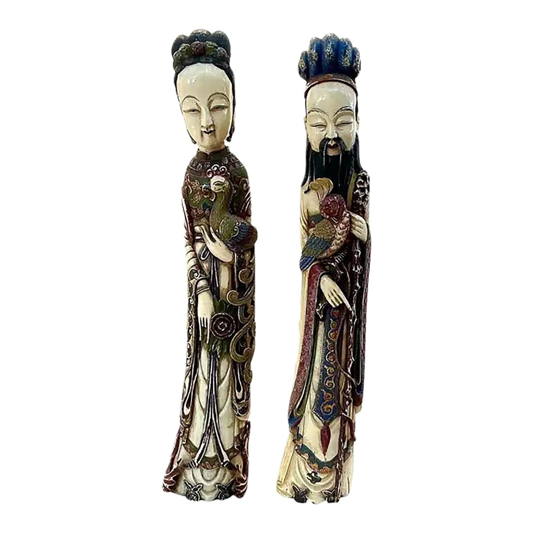Large Carved and Polychrome Chinese Figurines, a Pair: Impressive pair of large Chinese Carved and Polychromed Figurines that depict an elegant male and female in refined idealization and ceremonial presence. Each figure stands gracefully, dressed in elab