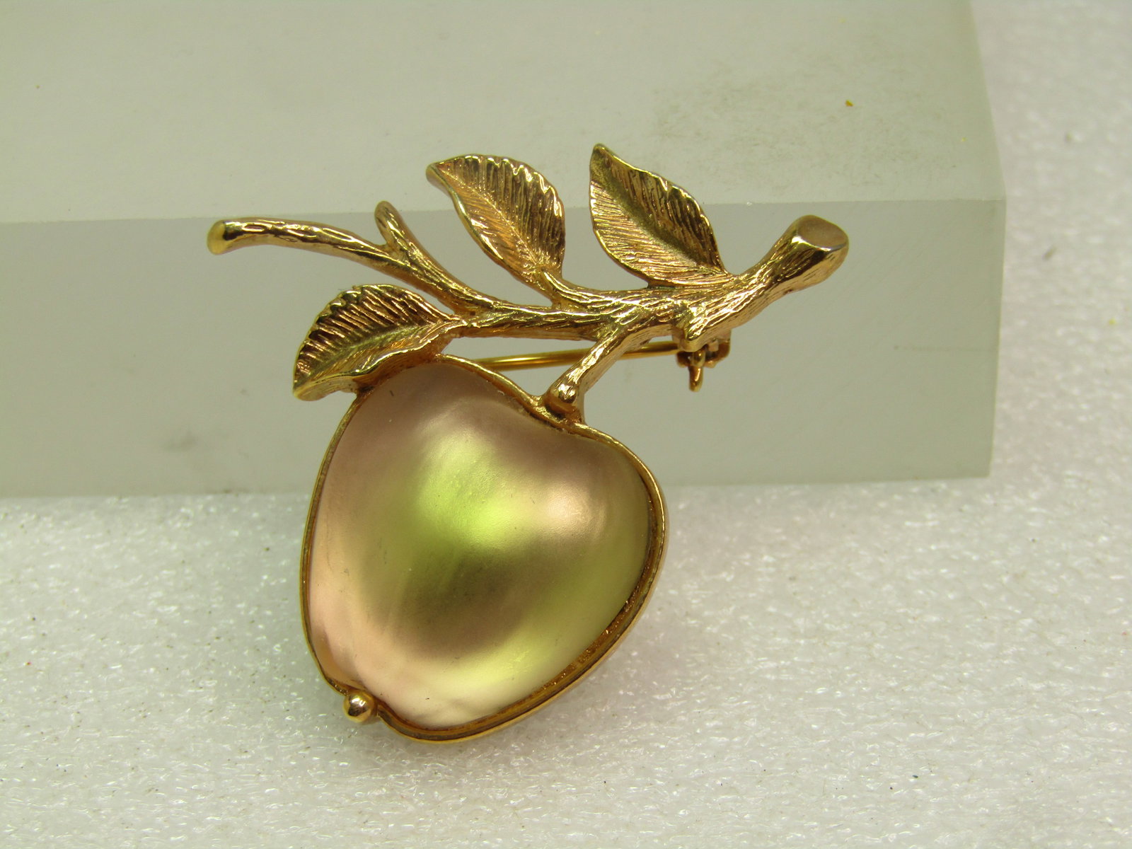 Vintage Frosted Glass Apple Brooch, Sarah Coventry, 1960's-1970's: Vintage Frosted Glass Apple Brooch, Sarah Coventry, 1970's. This is a pale yellow frosted glass that has hints of green and pink/lavender depending on the light. It has a stem and leaves ni textured g