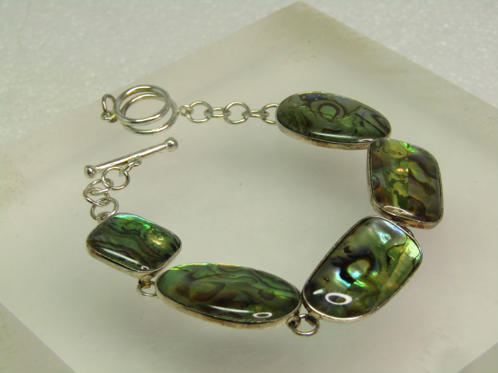 Vintage Sterling Silver Paua Shell Link Bracelet, 8", Signed LUC, 1980's-1990's: Vintage Sterling Silver Paua Shell Link Bracelet, 8", Signed LUC, 1980's-1990's. This has give Paua shell links in mixed shapes: two egg shaped or pear-shaped, a long rectangle with rounded corners, a