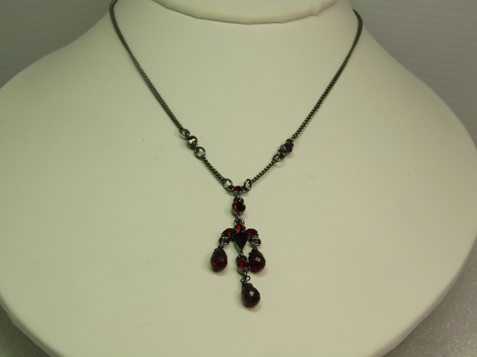 Titanium Tone Garnet Colored Beaded Necklace, 16"-18", 1980's-1990's. Signed: Titanium Tone Garnet Colored Beaded Necklace, 16"-18", 1980's-1990's. Signed. Faceted garnet colored pear-shaped beads dangle from a setting with set matching colored stones in marquise shaped, pear, 
