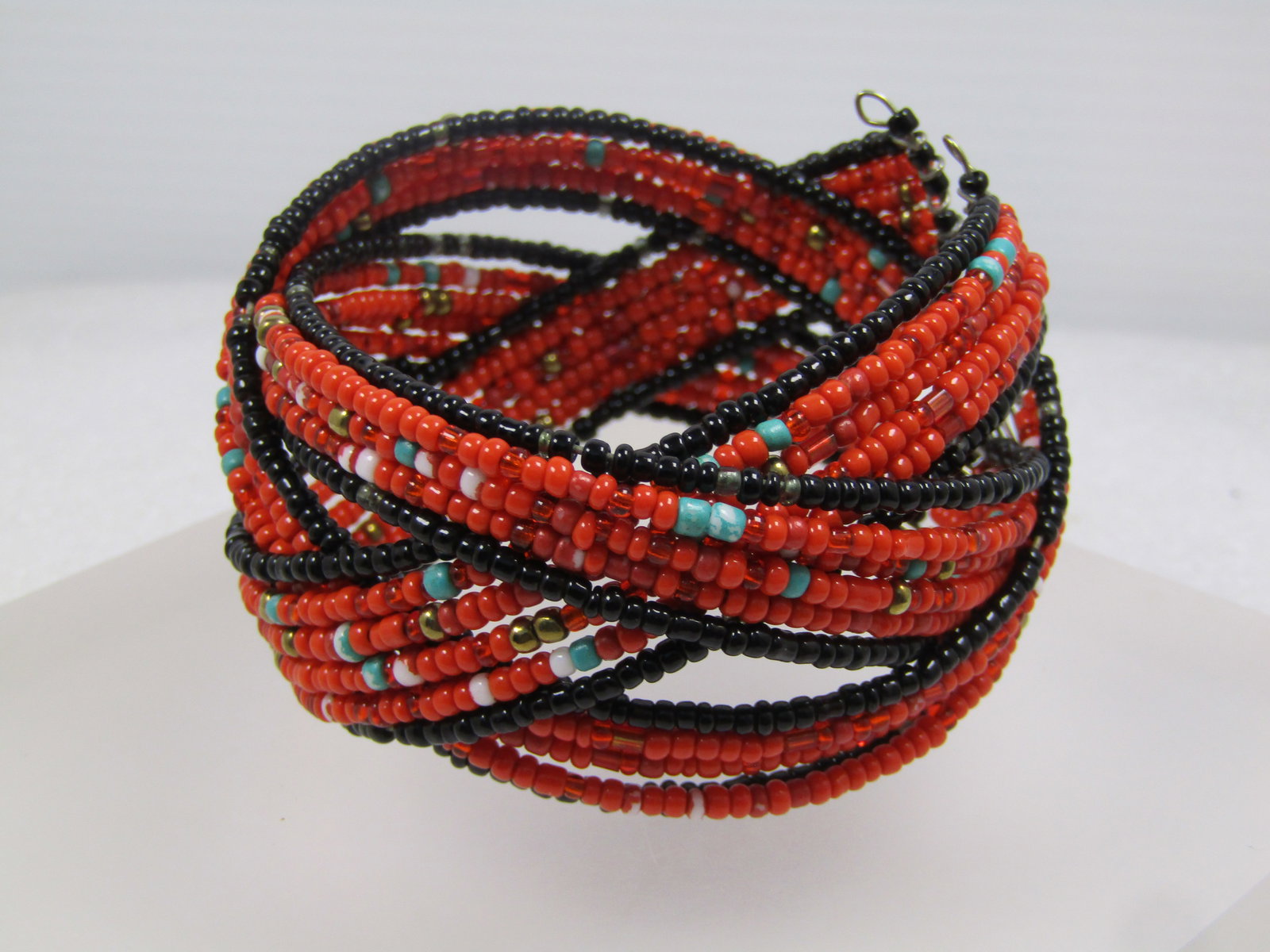 Vintage Orange/Black Seed Beaded Coiled Cuf Bracelet, 1980's, Great for Autumn Too.: Vintage Orange/Black Seed Beaded Coiled Cuf Bracelet, 1980's. This is appx. 6.75" at rest but opens when slipped over the wrist and will adjust to the size you need. It has six strands in three sectio