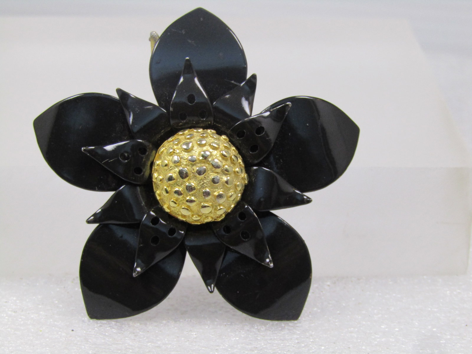 Vintage Black Enameled Floral Brooch, 1960's, Appx. 2": Vintage Black Enameled Floral Brooch, 1960's, Appx. 2". This has a raised bumpy gold tone center that is slightly over 1/2" round with pointed petals in two tiers with the top layer having three