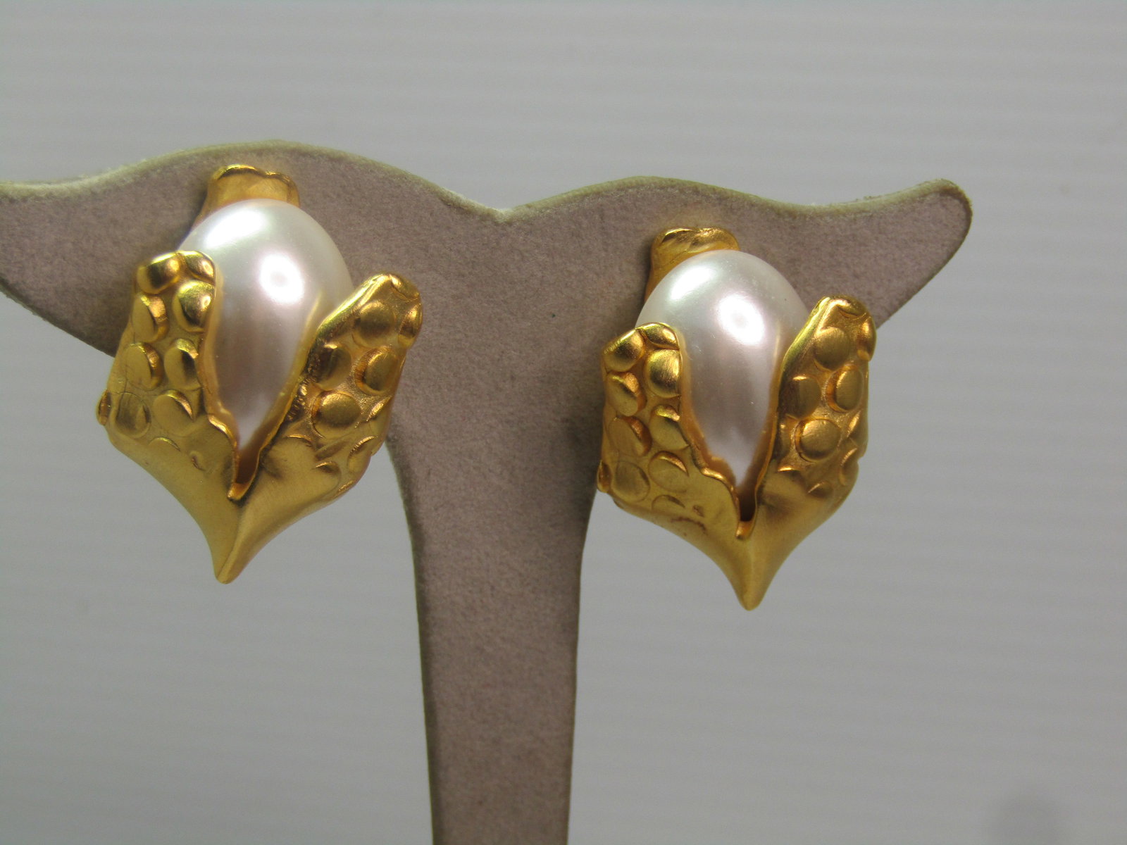 Vintage Gold Tone Faux Pearl Clip Earrings , Mod Design), 1980's-1990's: Vintage Gold Tone Faux Pearl Clip Earrings , Mod Design), 1980's-1990's. This looks like a mod version of an ear of corn with a center oval faux pearl cabochon and two front leaf-like ccents with rais