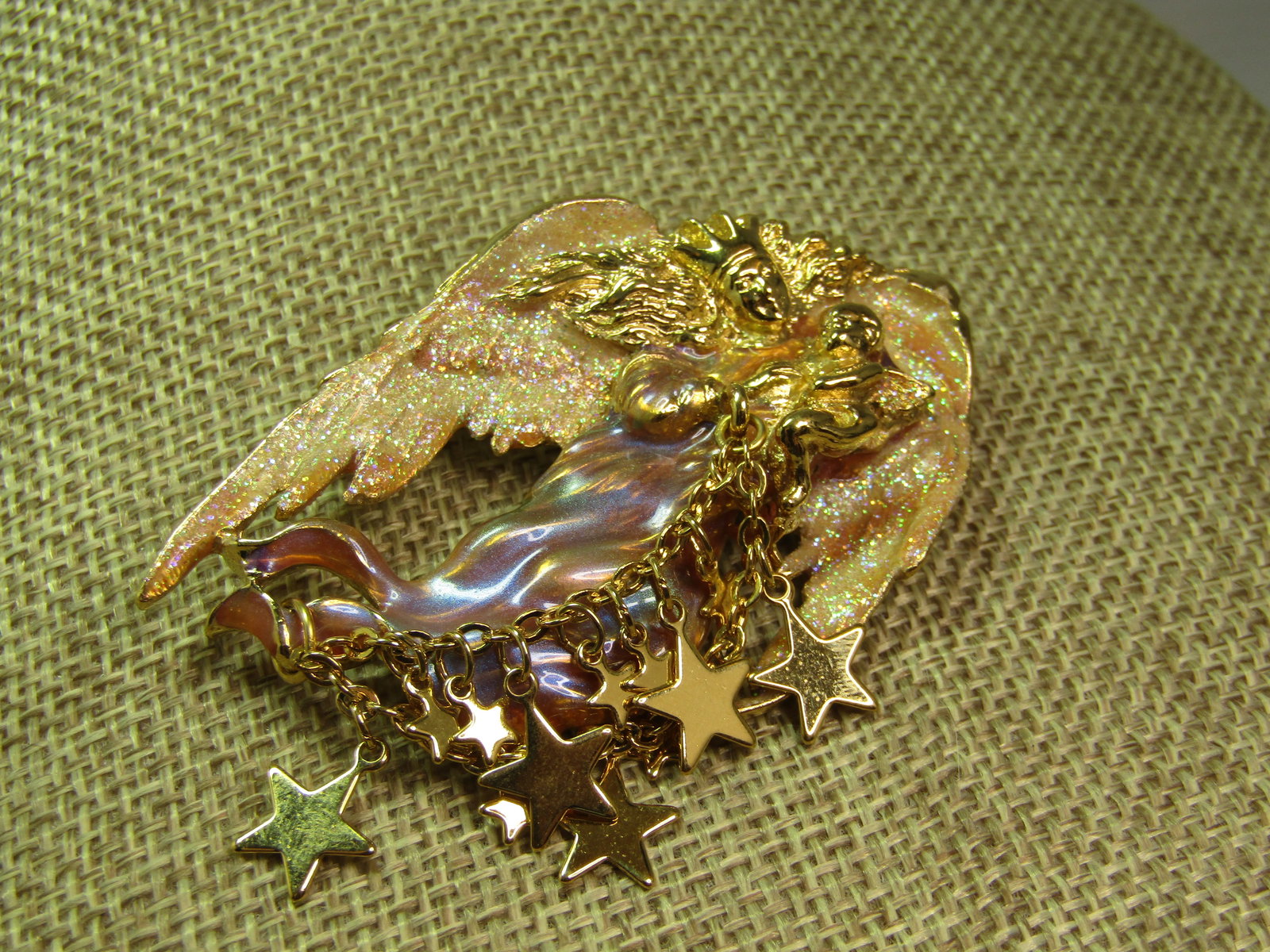 Enameled/Glittered Angel and Cherub Brooch, Dangling Stars, Signed Kirk's Folly, 1990's: Enameled/Glittered Angel & Cherub Brooch, Dangling Stars, Signed Kirk's Folly, 1990's. This is gold tone with an angel wearing a crown and holding a cherub with a glittered wing. She has white glitter