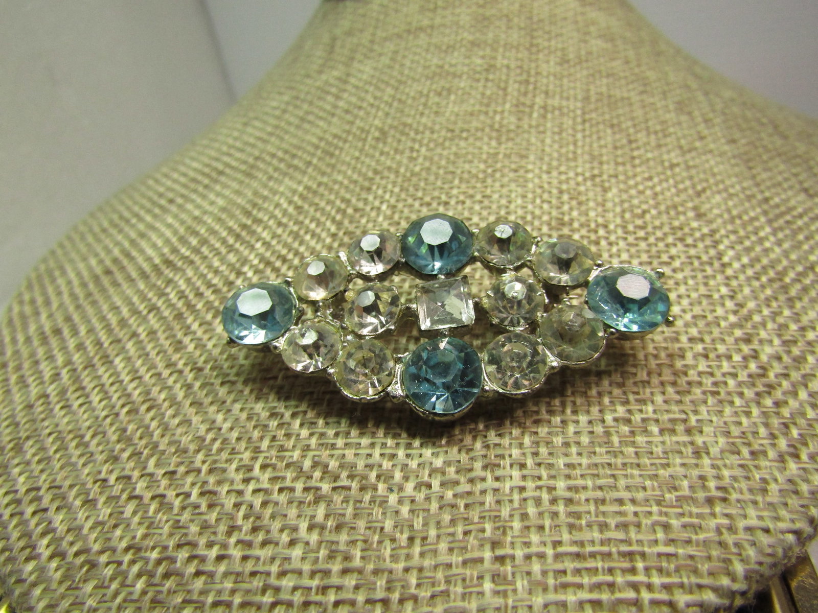 Vintage Blue & Clear Rhinestone Brooch, 1930's-1940's: Vintage Blue & Clear Rhinestone Brooch, 1930's-1940's. Silver tone cast metal brooch which is pointed on the ends and top/bottom - creating an elongated diamond shape with a round blue stone at each p