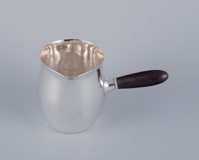 Georg Jensen pitcher in sterling silver with an ebony handle.: Title:Georg Jensen pitcher in sterling silver with an ebony handle. Brand:SILVER & JEWELRY Description:Georg Jensen pitcher in sterling silver with an ebony handle.; is backordered and will ship as so