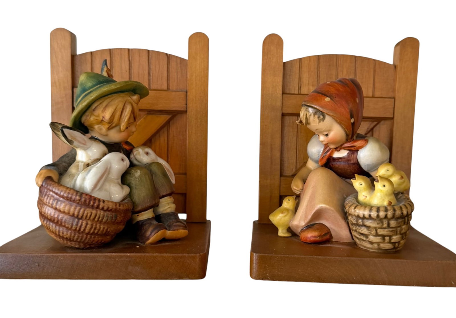 Hummel Goebel Bookends, Boy with Rabbits and Girl with Chicks: A charming pair of Hummel Goebel ceramic bookends, depicting a boy with rabbits and a girl with chicks. Each bookend features a hand-painted ceramic figure attached to a wooden bookend base designed t