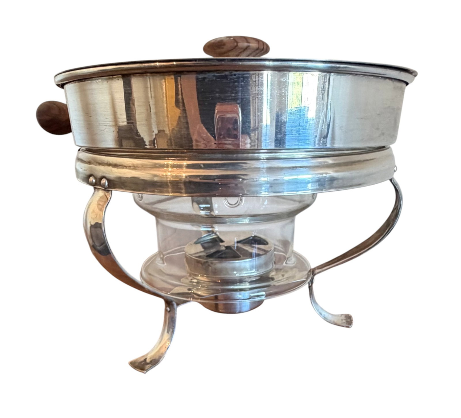 Silver-Plated Chafing Dish with Wooden Accents: This elegant chafing dish features a silver-plated warming pan and stand, accented with dark wooden handles on the lid and the side of the pan. The set includes a glass insert for the burner, making