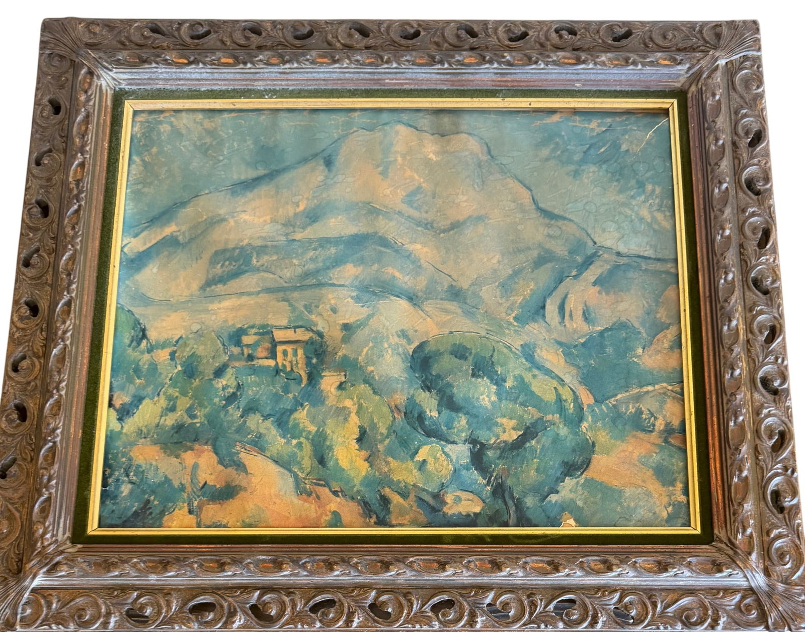 Landscape Oil Painting with Ornate Frame: An intriguing landscape oil painting, likely dating from the mid-20th century, presented in a richly carved, dark wood frame. The painting depicts a mountainous scene with a structure nestled amongst