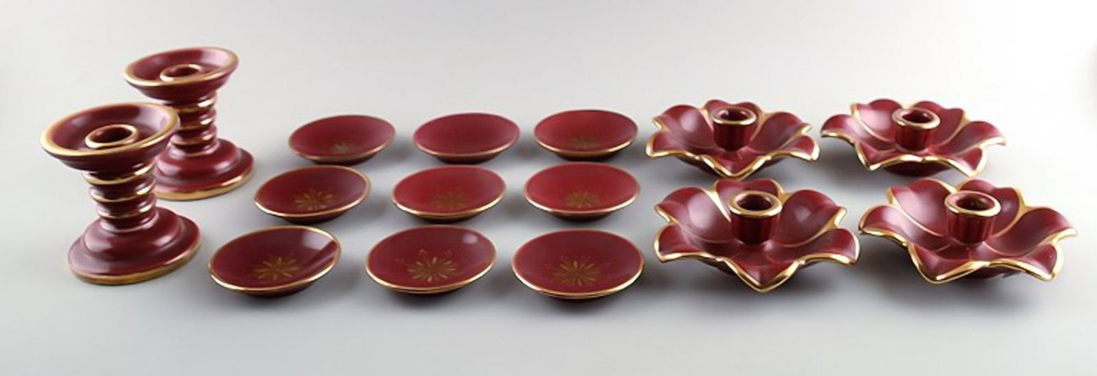 Collection of 'Red Rubin' pottery with red glaze with gold, Upsala-Ekeby, Gefle. Design Arthur: Brand: Upsala Ekeby Collection 'Red Rubin' pottery with red glaze with gold, Upsala-Ekeby, Gefle. Design Arthur Percy. Consisting of six candlesticks and 9 small dishes. Largest candlestick measures: