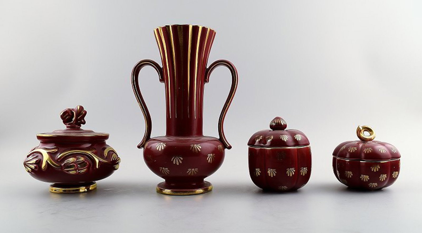 Collection of 'Red Rubin' pottery with red glaze with gold, Upsala-Ekeby, Gefle. Design Arthur: Brand: Upsala Ekeby Collection of 'Red Rubin' pottery with red glaze with gold, Upsala-Ekeby, Gefle. Design Arthur Percy. Consisting of 3 lidded vases, and a large vase. The largest vase measures 22 c