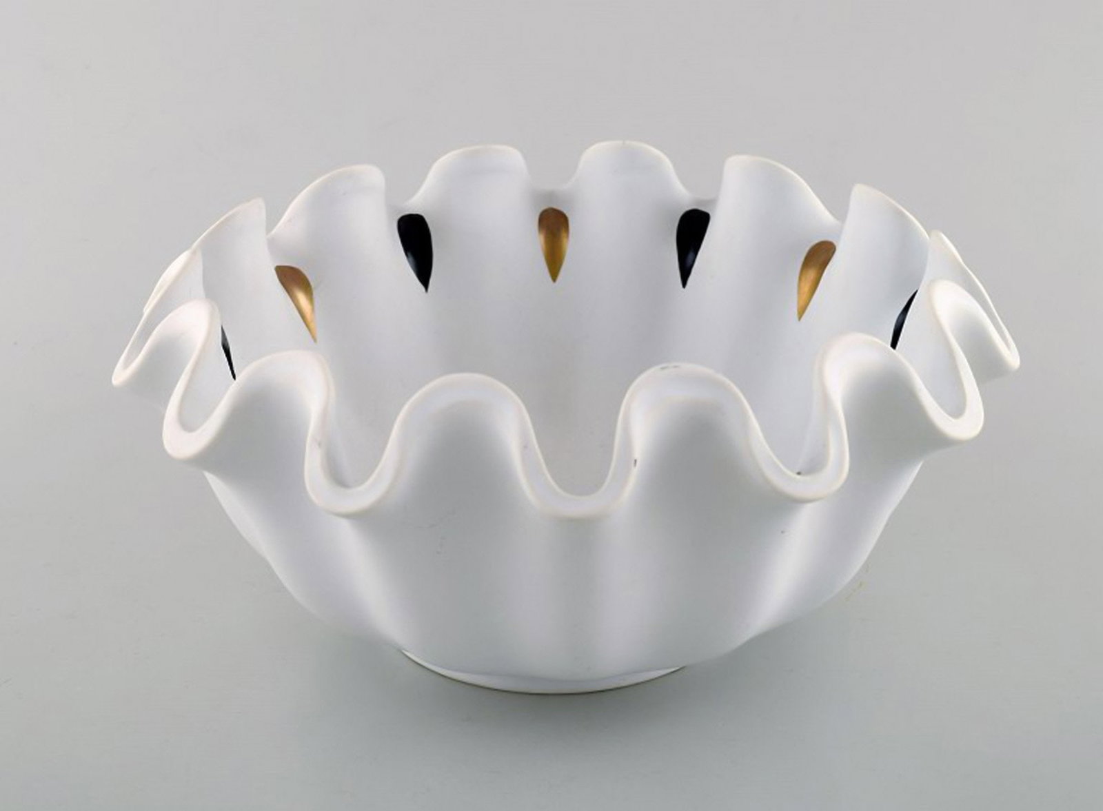 Wilhelm Kåge for Gustavsberg. Large curved bowl in glazed ceramic with ruffled edge. Hand: Brand: Gustavsberg Wilhelm Kåge for Gustavsberg. Large curved bowl in glazed ceramic with ruffled edge. Hand painted black and gold. Mid 20th century. Stamped. In very good condition. Measures: