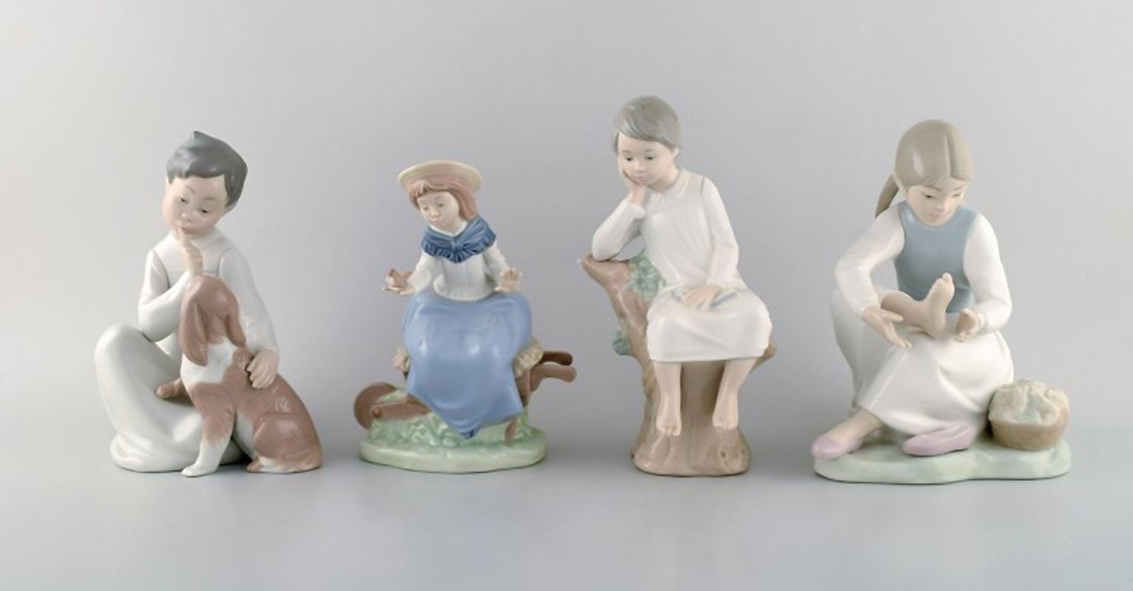 Lladro and Nao, Spain. Four porcelain figurines of children. 1980 / 90's.: Brand: Lladro Lladro and Nao, Spain. Four porcelain figurines of children. 1980 / 90's. Reserve: $210.00 Shipping: Domestic: Shipping rates are determined by destination International: Foreign shippin