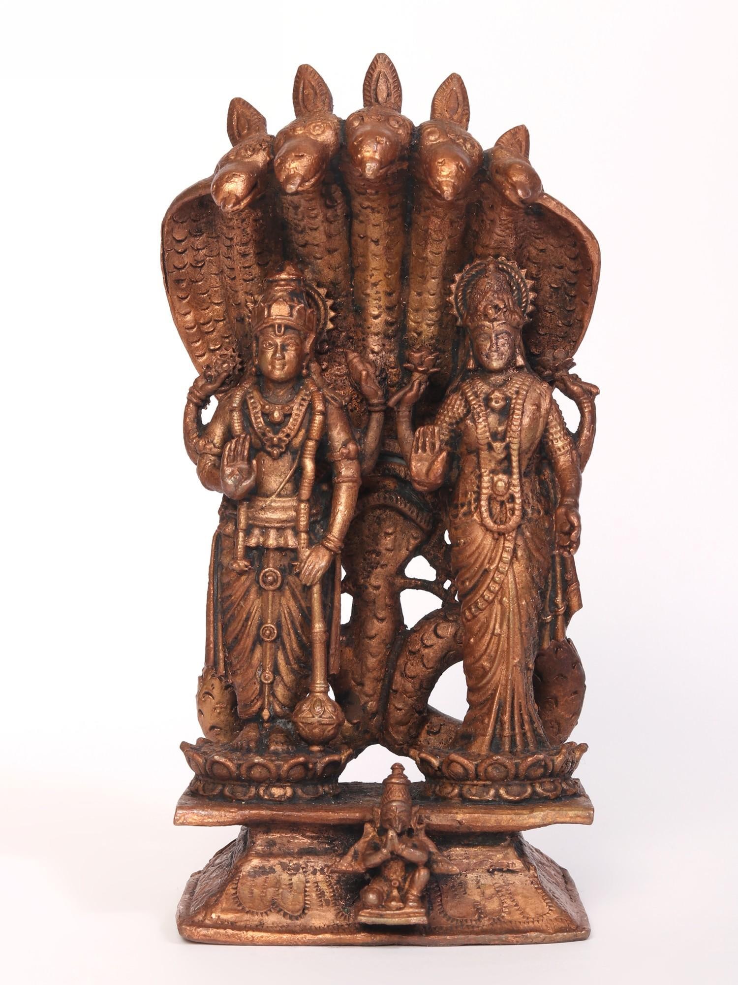 6" Small Standing Vishnu Lakshmi Copper Idol Protected by Sheshnag: Title: 6" Small Standing Vishnu Lakshmi Copper Idol Protected by Sheshnag Description: In this sacred copper rendition, divinity unfolds like a cosmic tapestry. Lord Vishnu, resplendent in his regal s