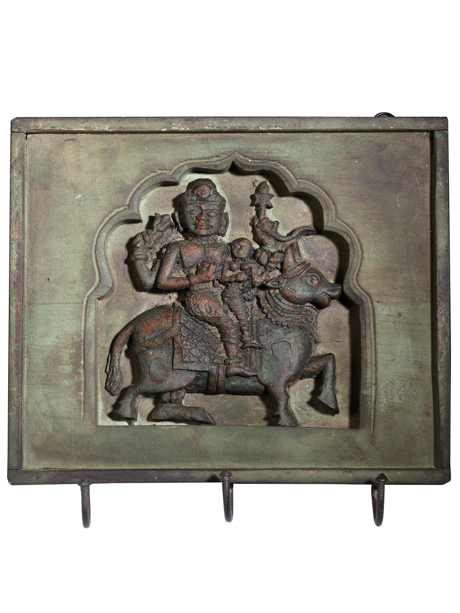 12" Wood Carved Shiva Parvati Seated on Nandi | Wall Hanging: Title: 12" Wood Carved Shiva Parvati Seated on Nandi | Wall Hanging Description: This wood-carved Shiva Parvati seated on Nandi is a wall hanging. The image carved here is the Pradosh Murti of Shiva a