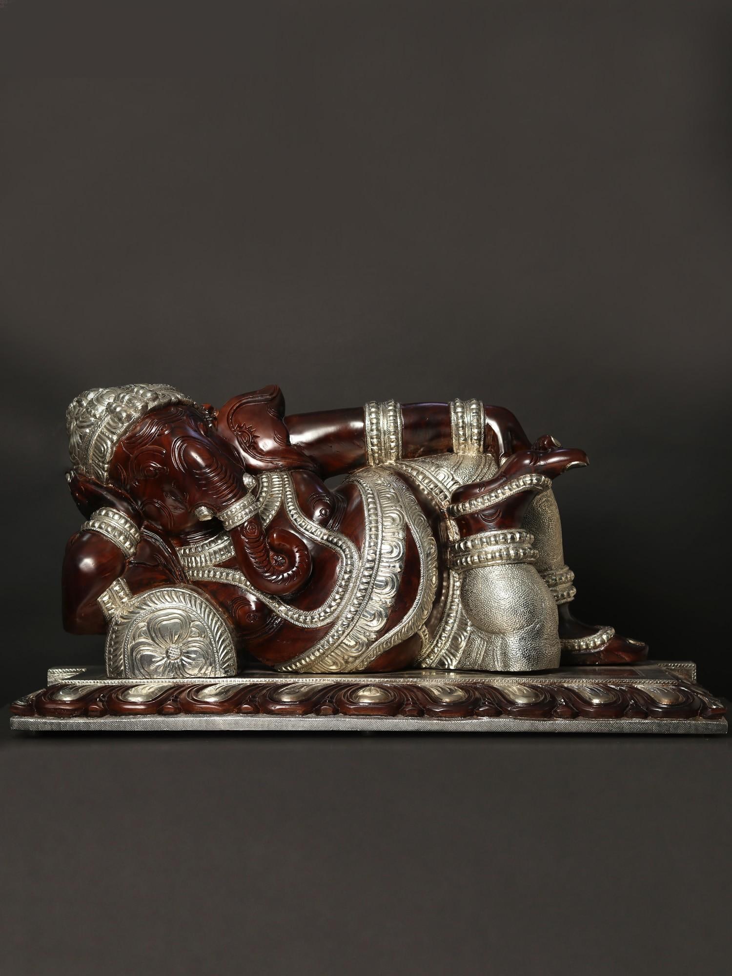 41" Large Relaxing Lord Ganesha Idol with Silver Finish | Wood Carved Statue: Title: 41" Large Relaxing Lord Ganesha Idol with Silver Finish | Wood Carved Statue Description: Lord Ganesha, revered in Hindu iconography, symbolizes wisdom, prosperity, and the removal of
