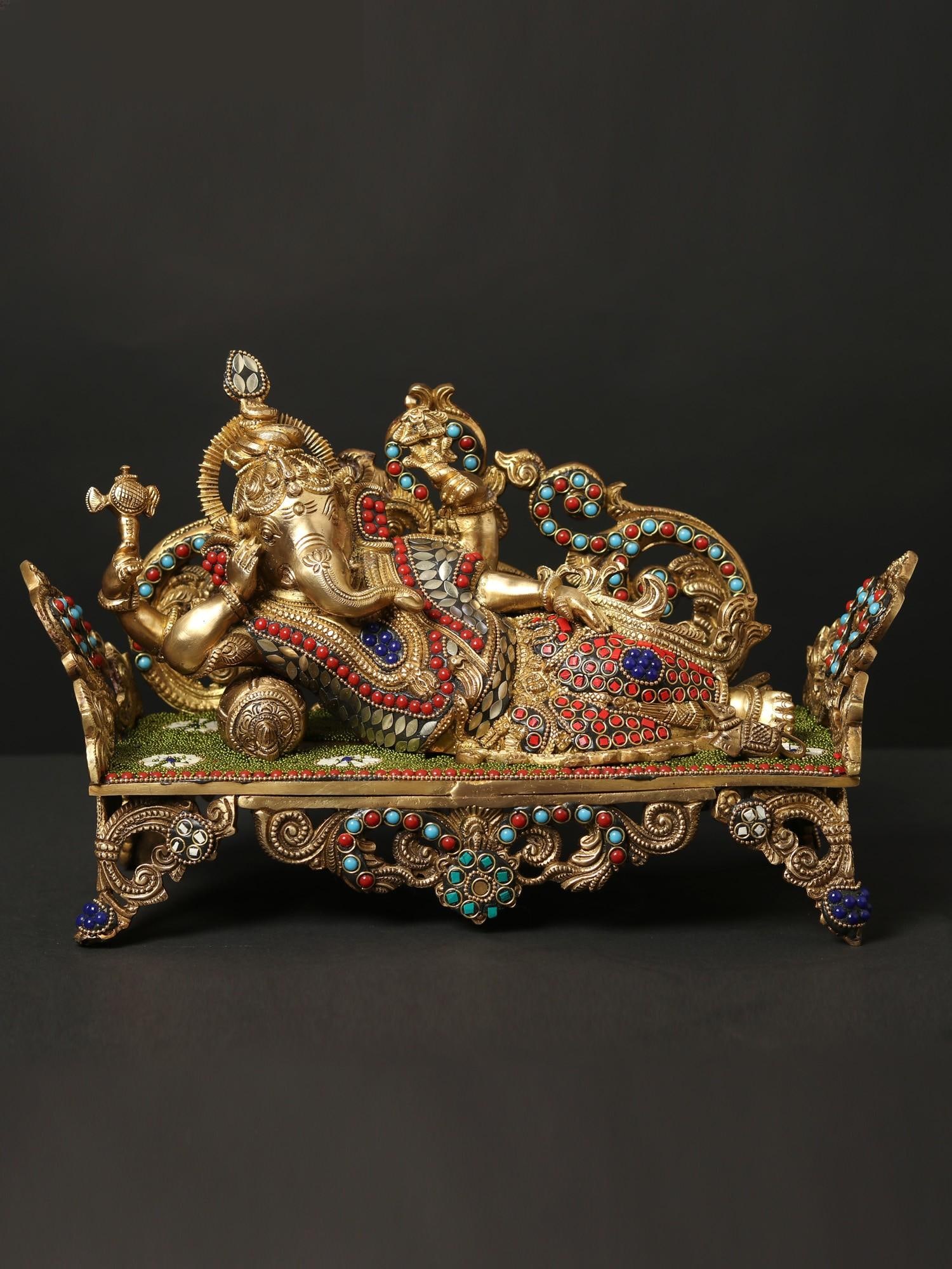 14" Relaxing Lord Ganesha Idol | Brass Statue with Inlay Work: Title: 14" Relaxing Lord Ganesha Idol | Brass Statue with Inlay Work Description: The image of a reclining Ganesha holds cultural significance as it portrays the elephant-headed deity in a relaxed