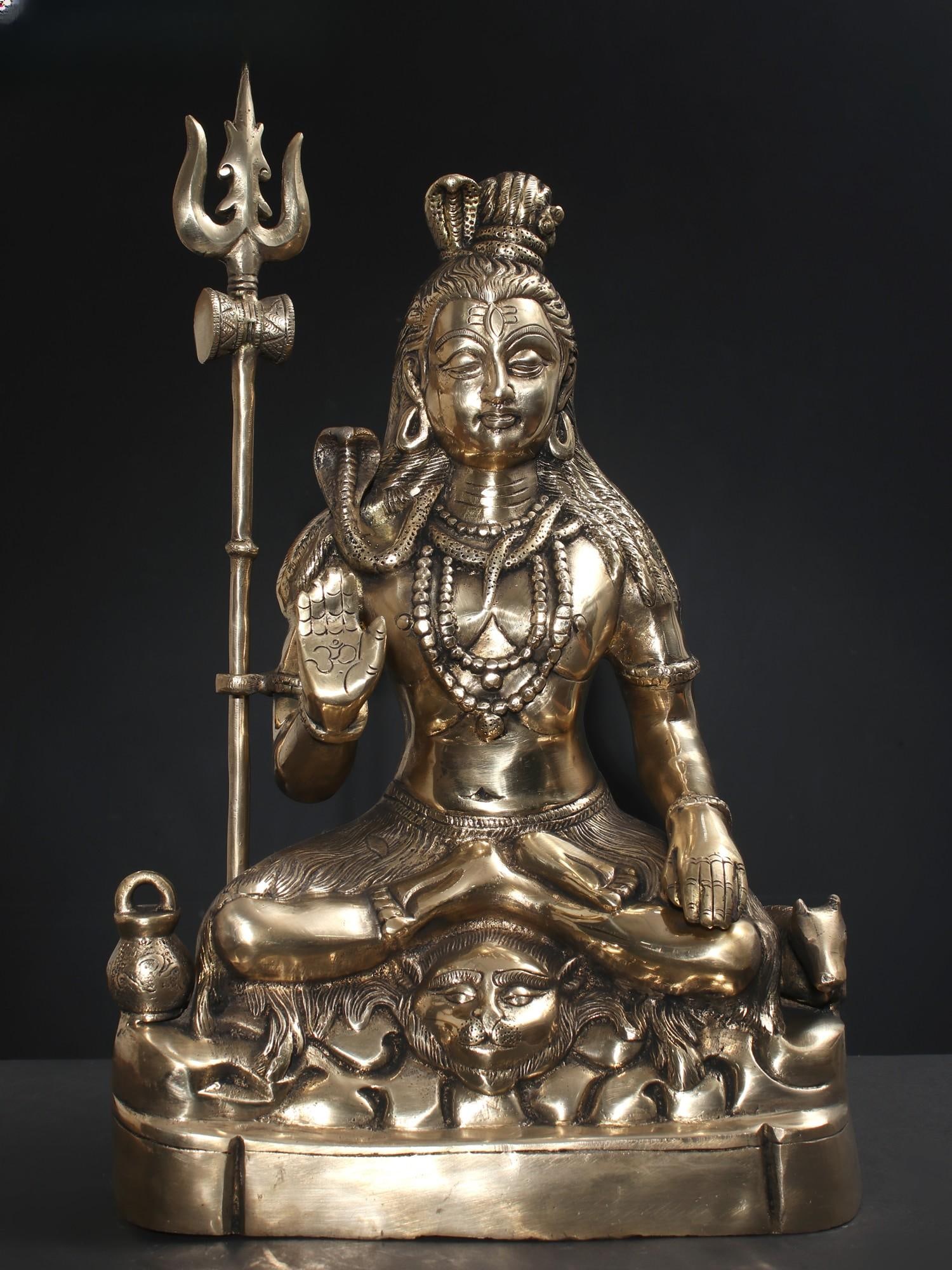 17" Sitting Lord Shiva Idol in Blessing Gesture | Brass Statue: Title: 17" Sitting Lord Shiva Idol in Blessing Gesture | Brass Statue Description: The brass sculpture of Sitting Lord Shiva in a Blessing Gesture holds profound significance in Hinduism, evoking a se