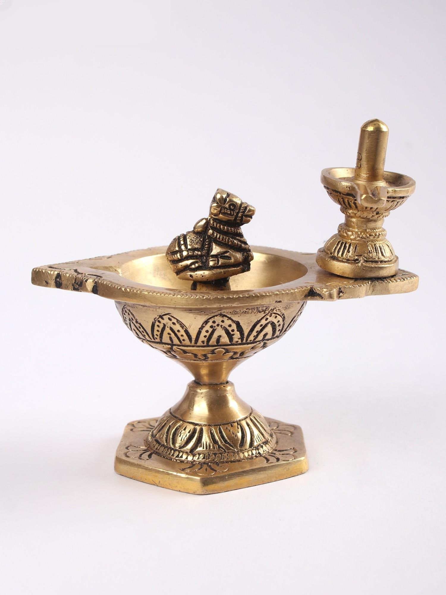 4" Small Brass Nandi Shivalinga Diya (Lamp): Title: 4" Small Brass Nandi Shivalinga Diya (Lamp) Description: This Small Brass Nandi Shivalinga Diya (Lamp) is a distinctive ritual object, embodying profound symbolism in its design. At its center,