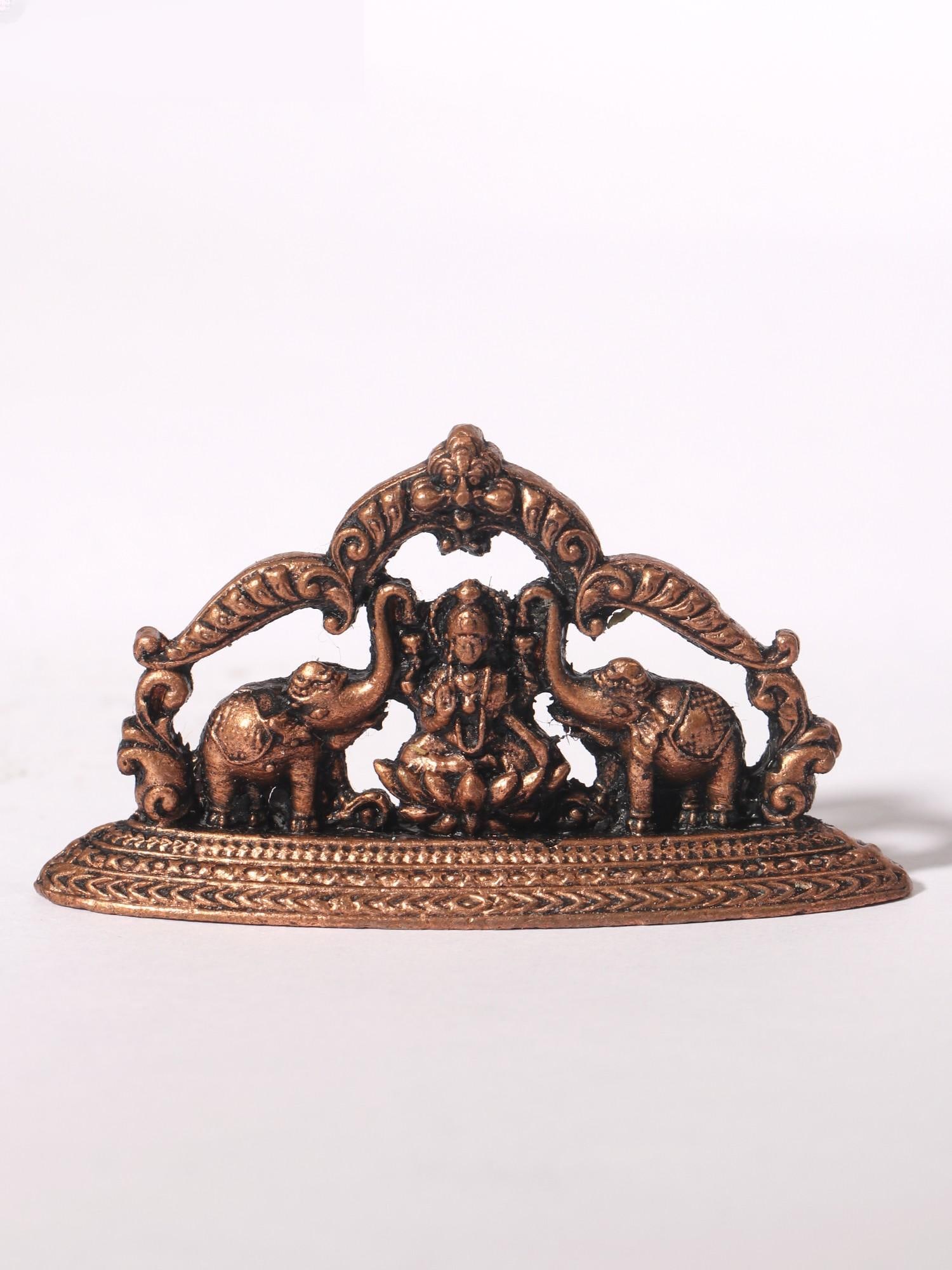 2" Small Goddess Gajalakshmi Idol with Kirtimukha Arch | Copper Statue: Title: 2" Small Goddess Gajalakshmi Idol with Kirtimukha Arch | Copper Statue Description: This Small Goddess Gajalakshmi with Kirtimukha Arch Copper Statue is a divine and aesthetically pleasing addi