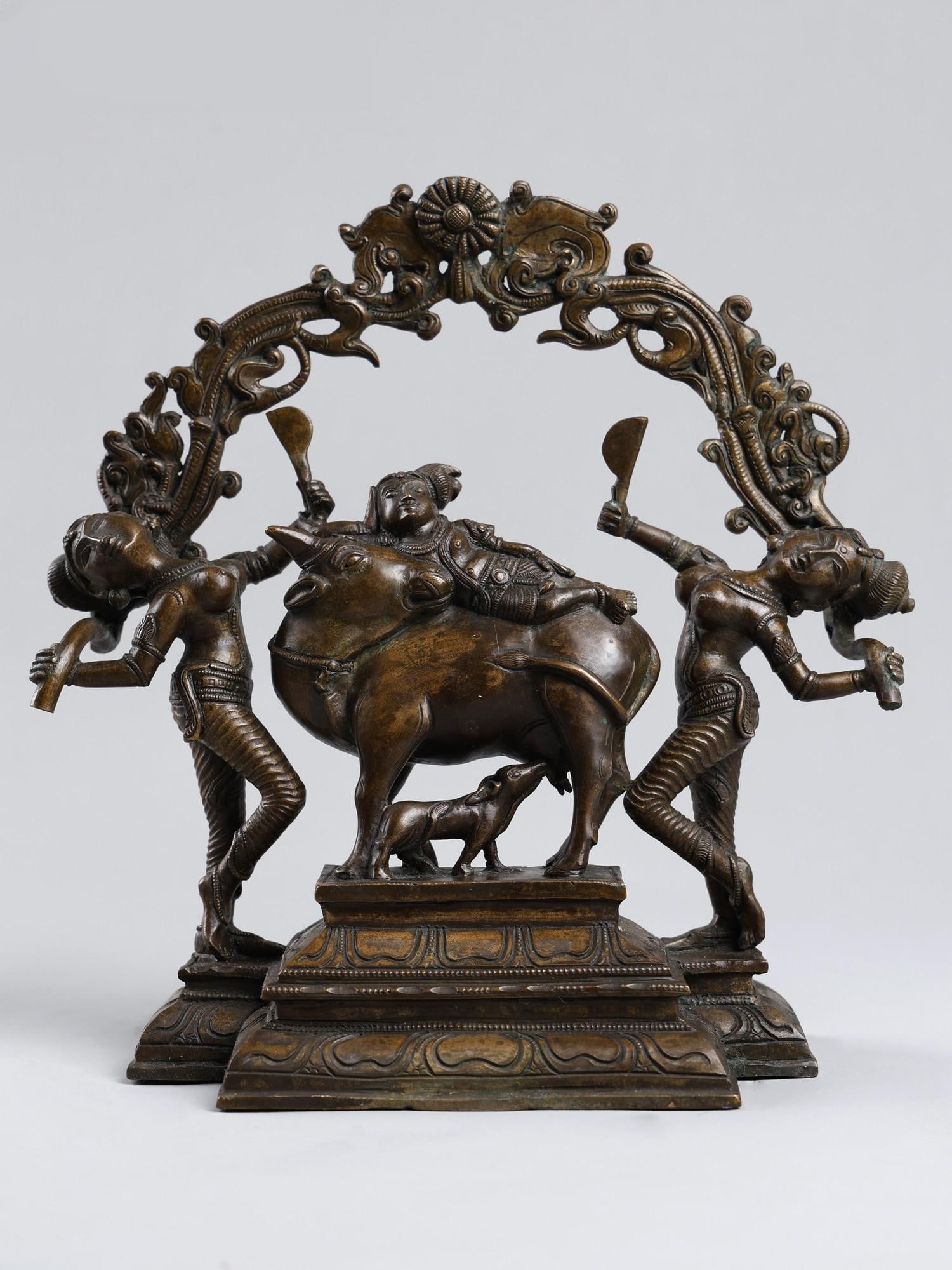 11" Raja-Gopala: Krishna as a King with Cow and Gopis | Bronze Statue: Title: 11" Raja-Gopala: Krishna as a King with Cow and Gopis | Bronze Statue Description: Overflowing with the sweetness of Krishna’s divine Lila, this Swamimalai bronze is an unparalleled artwo