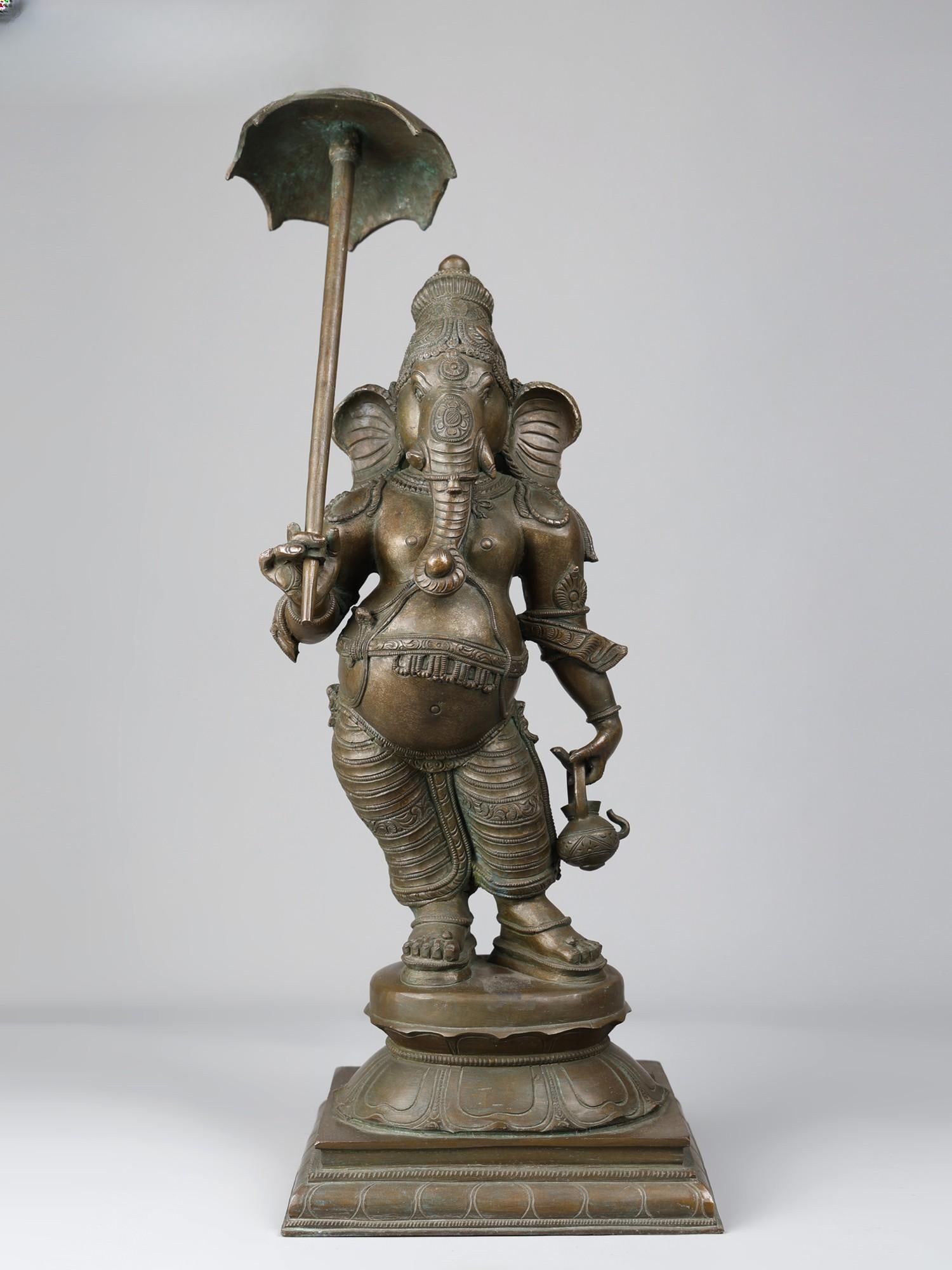 22" Umbrella Ganesha Panchaloha Bronze Statue: Title: 22" Umbrella Ganesha Panchaloha Bronze Statue Description: Umbrella, Kamandalu (water pot), and Khadau (wooden footwear)- carrying the attributes of ascetics, Ganesha in this unique bronze stat