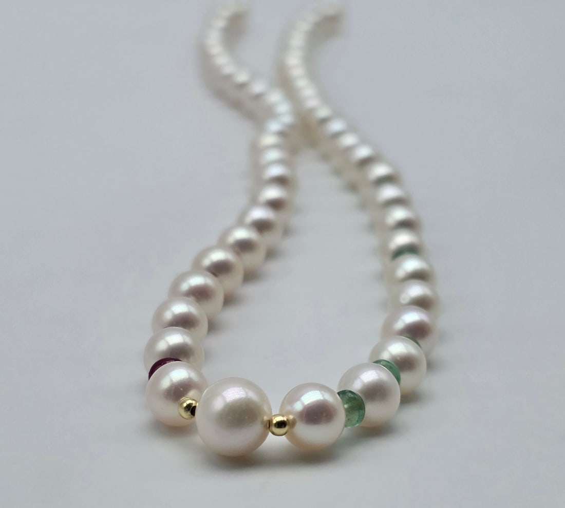 Akoya pearl necklace with emeralds and rubies, with an 18kt (750) yellow gold clasp and a central: Title:Akoya pearl necklace with emeralds and rubies, with an 18kt (750) yellow gold clasp and a central pearl and gold spheres Description:Akoya pearl necklace with emeralds and rubies, with an 18kt